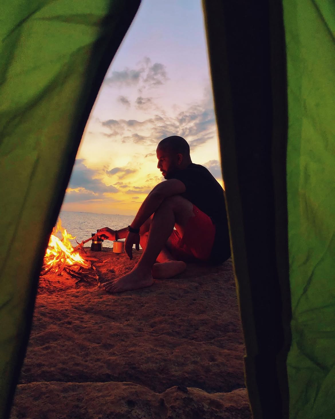 Person looking toward the sunset from a tent