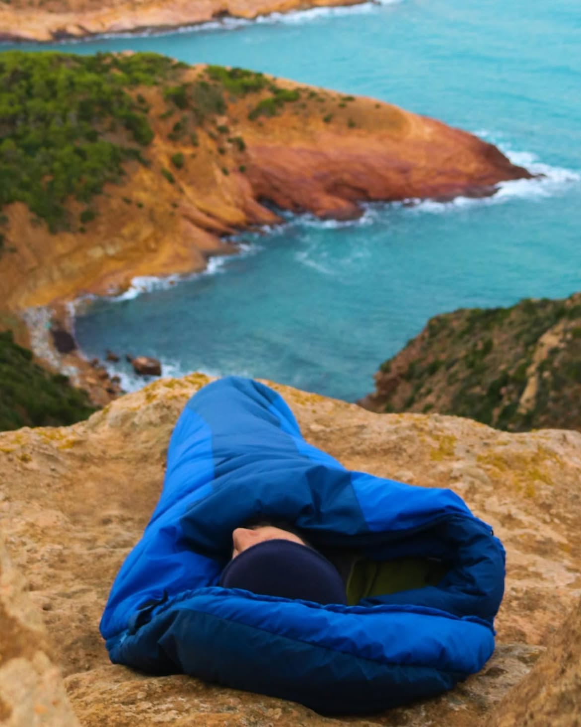 Person resting above a blue cove