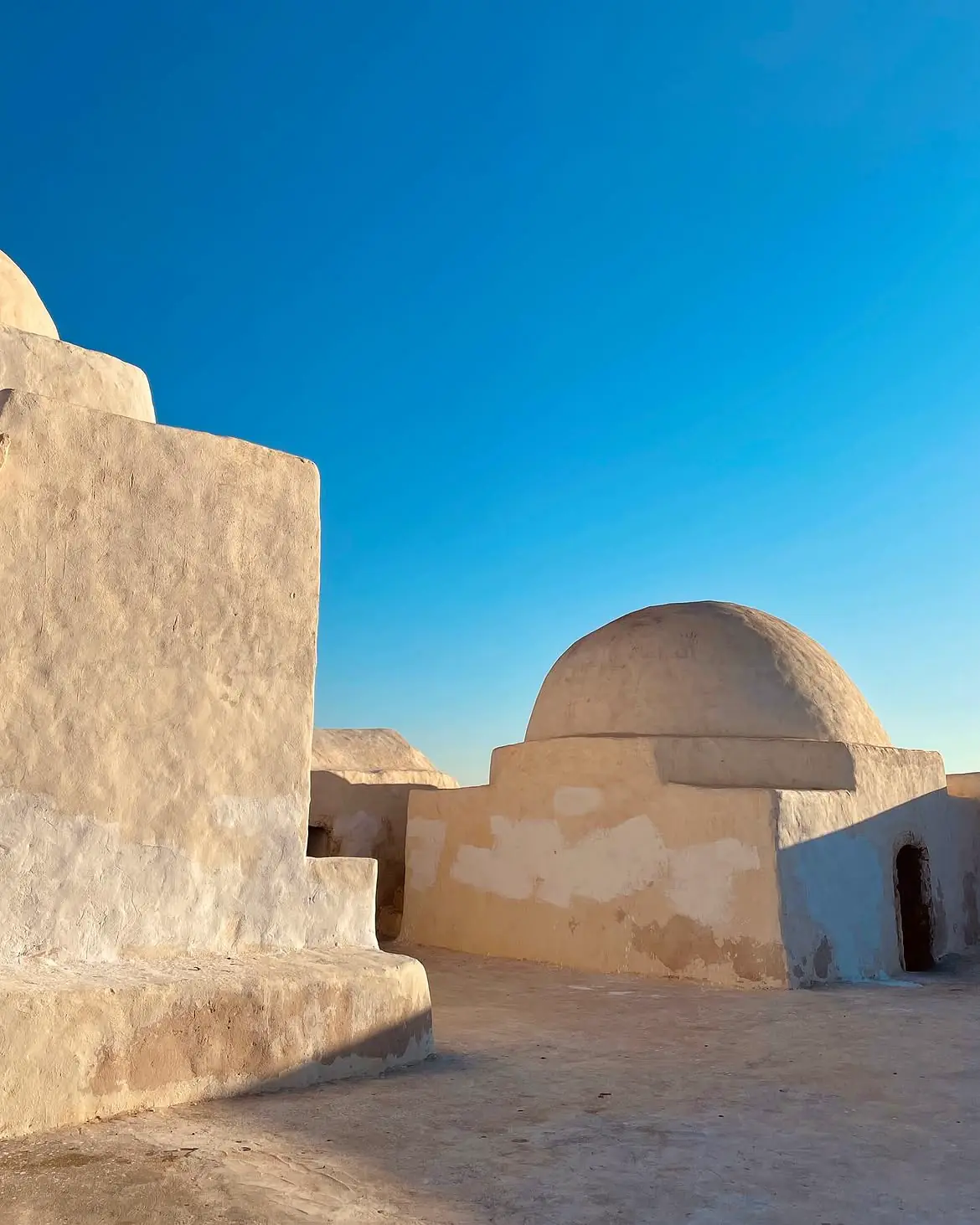 Whitewashed buildings and a dome under clear sky