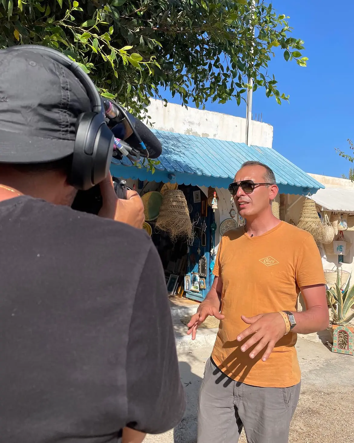 A camera operator films Rabii speaking outdoors